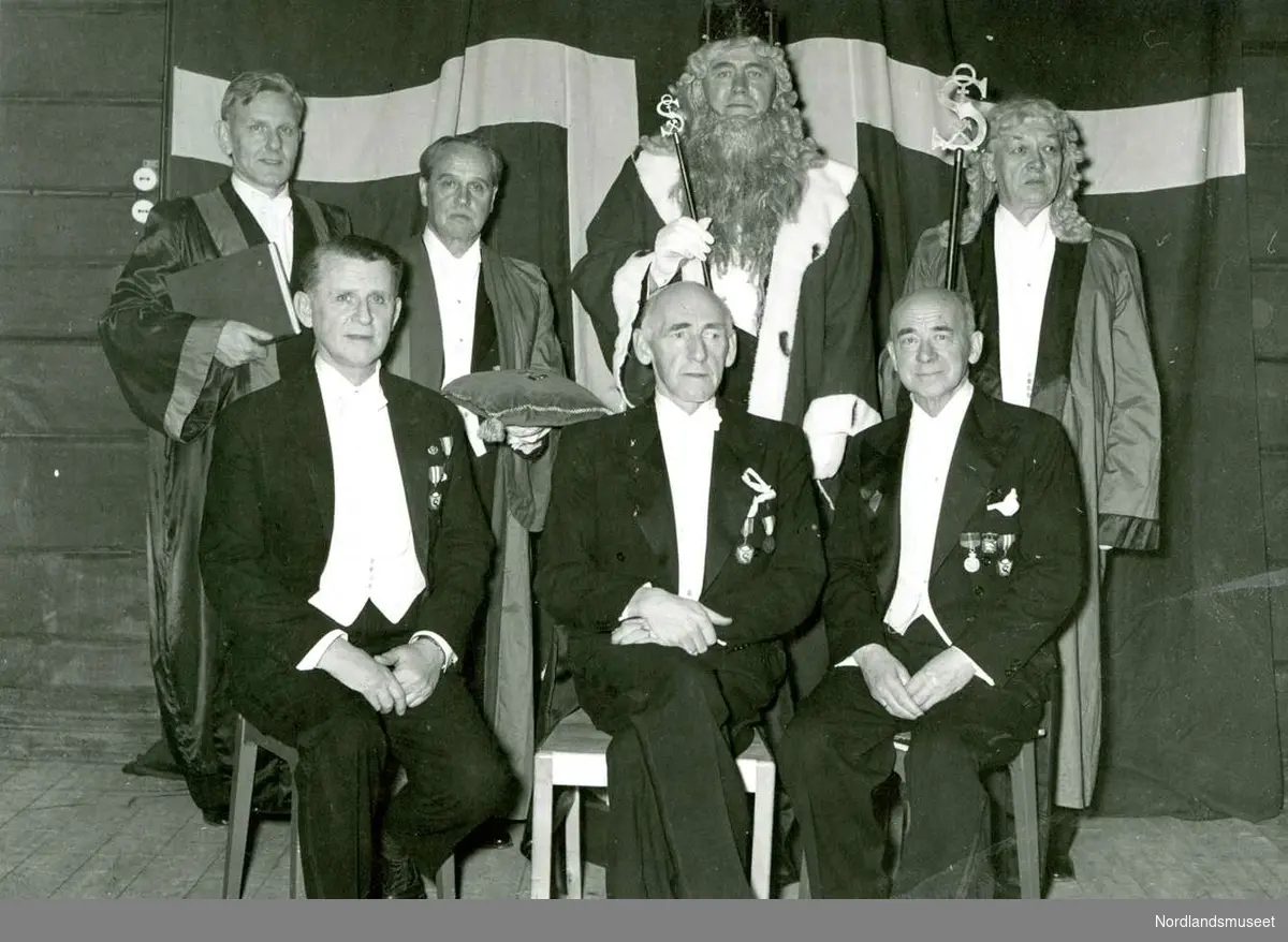 Mennesker. 
Ridderne Bjarne Lie og Einar Hugaas, H. M. Sulitjelmakongen Ragnar Christoffersen og Ordenskollegiet den 29. desember 1956. 
Foto Ukjent.
