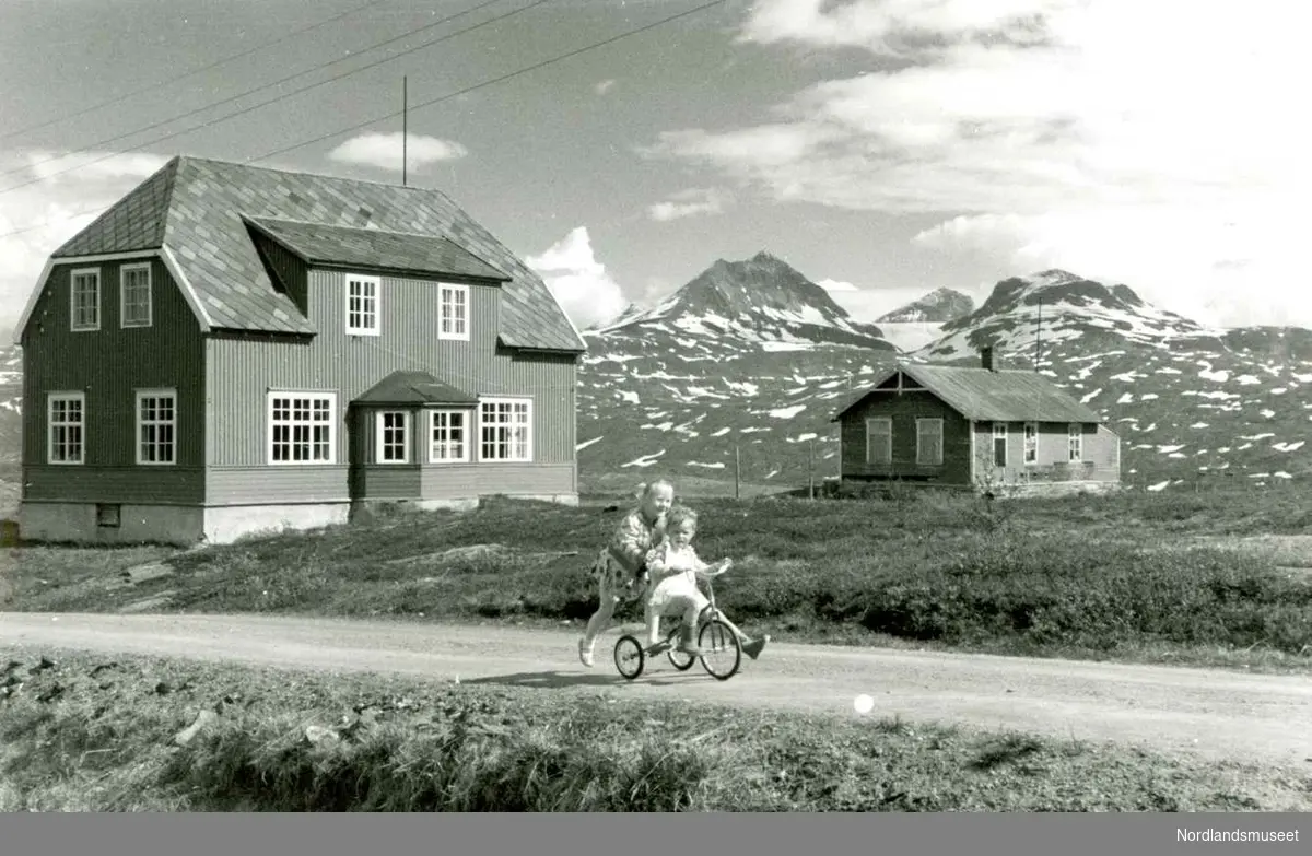 Jakobsbakken. 
Barn i lek foran Nyskolen med internat (1919) til venstre og Gammelskolen (1908). Hun som sitter på sykkelen er Beate Urheim. Foto Ukjent.