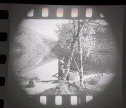 Fotografi av en mann som holder en fiskestang som står vedsi