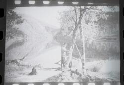 Fotografi av en mann som holder en fiskestang som står i en 