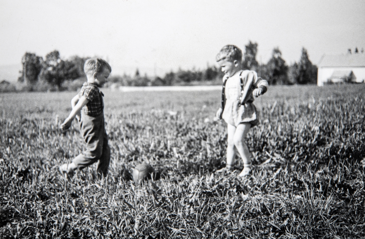 To gutter som sparker fotball. Barnelek. Fra venstre: Trond Furulund (f. 1957) og Bjørn Otto Kløvstad (f. 1958) i Basterudvegen i Ottestad i 1961.
