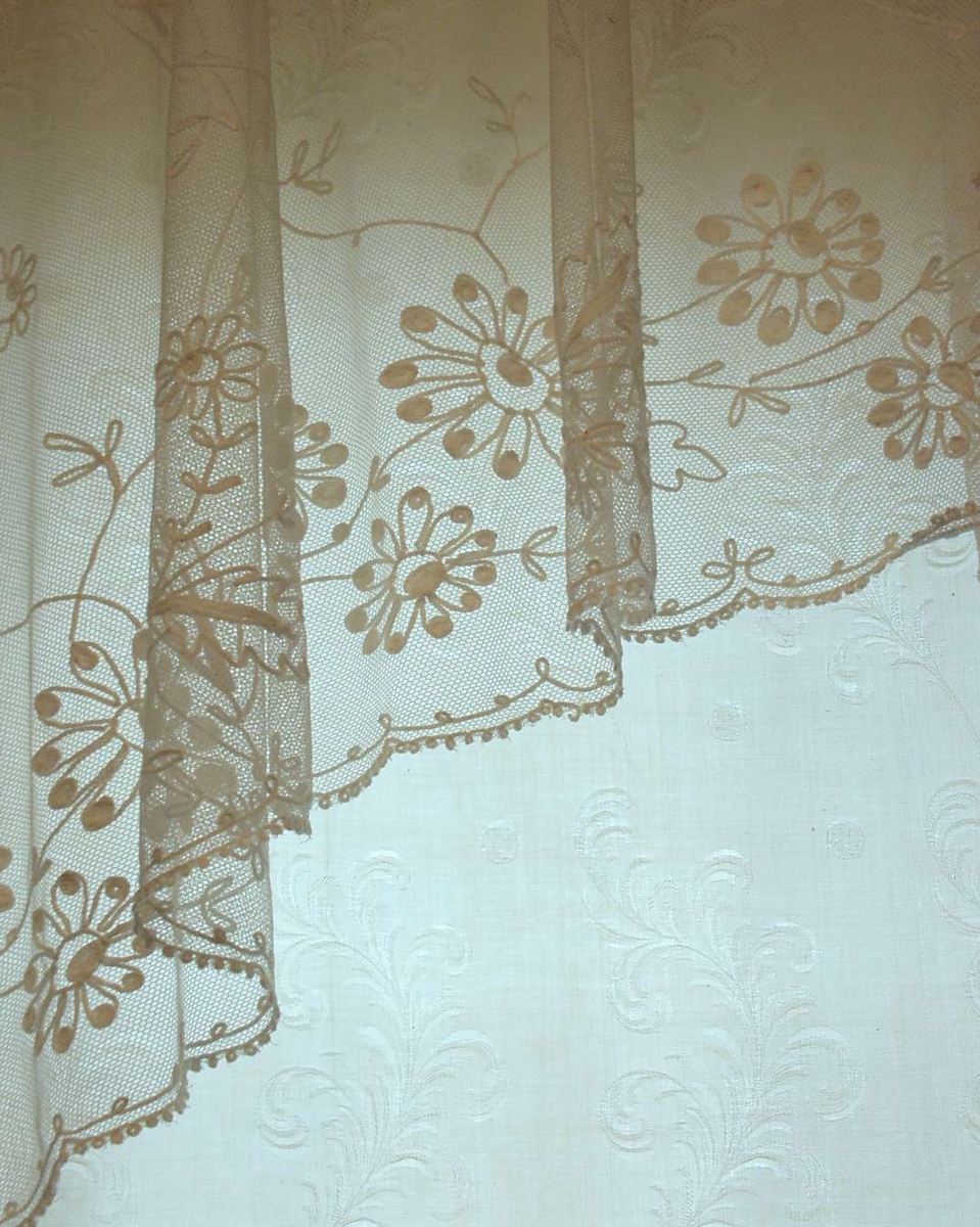 En bredde 150 cm er delt i to. 13-14 cm bord i ene siden med rettstrekte stilker, blad og blomster. Resten  av gardinen enkle, skråstilte tambursømlinjer som danner ruter 40 cm høye, 20 cm brede, vekselsvis to og tre hele ruter i høyden. Kantavslutning med åpen løkkebord og ytterst tett løkkebord i ene siden inn mot vinduet, i andre siden påsydd smal maskinsydd blonde av langsgående ovaler. Pga deling må annenhver gardin henge med vrangen ut.