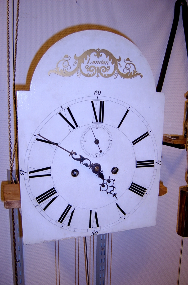 Uret er et tradisjonelt gulvur laget i England. Tallskiven er av typen " White dial" hvitmalt metallskive som her er merket med "London". Uret har romertall og sekundviser. Det er ingen andre signaturer på urskive eller urverk som kan knytte uret til produsenten.  Urverket er laget i meget god kvalitet, litt over gjennomsnittlig for tilsv. urverk. Bakplatinen / verkplaten er polert og alle deler i urverket er godt bearbeidet i god engelsk tradisjon. Disse urverk ble laget i hele Storbritannia og tallskiven viser at uret ikke tilhører ur laget i de store byer. Ur med slike malte tallskiver betegnes som landsklokker og avviker med sin malte tallskive fra Londonurmakeriets fine messingskive med støpte ornamenter. Under demontering fremkom det at uret hadde vært til reparasjon flere ganger tidligere. Urverket har en tilbakevikende slepegang i normal engelsk type. Slaget er av typen rekkeslag med repetérarm og slag på hel time. (redigert fra urmakermester Erik Ødegaards rapport)