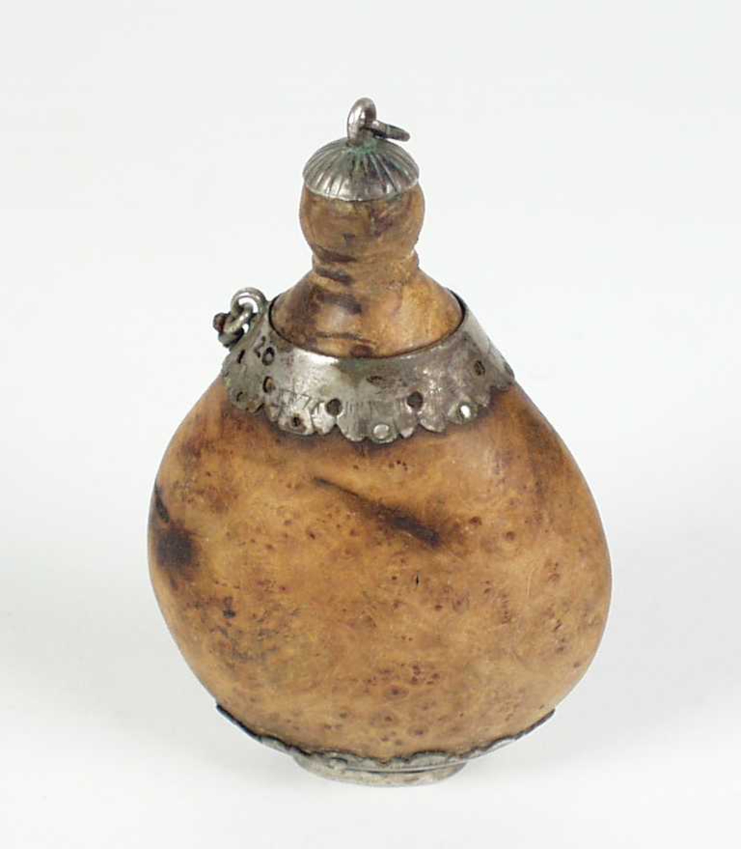 Snusflaske i valbjørk. Den har en liten skrukork og sølv dekor. Det har vært en lenke til, men den mangler.