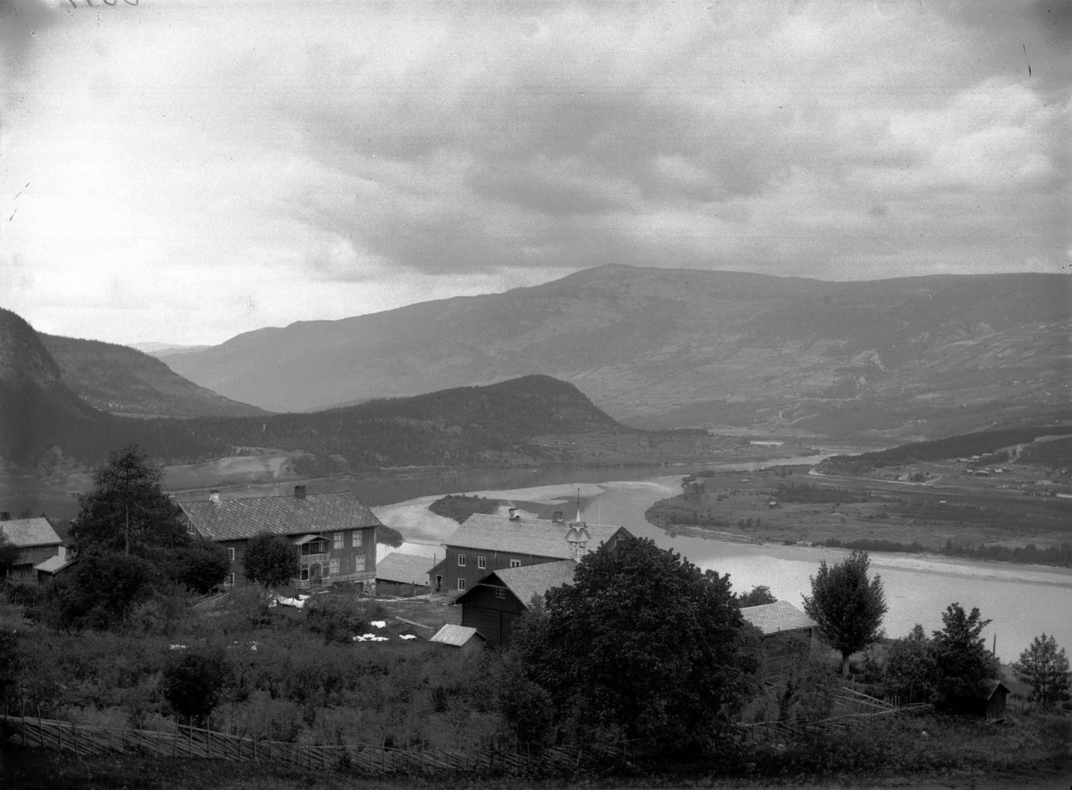 Kort: S.Fron. 7/7. 1902. Gaarden Isum ovenfra. Bolighus, driftsbygninger, trær, elv, fjellformasjoner