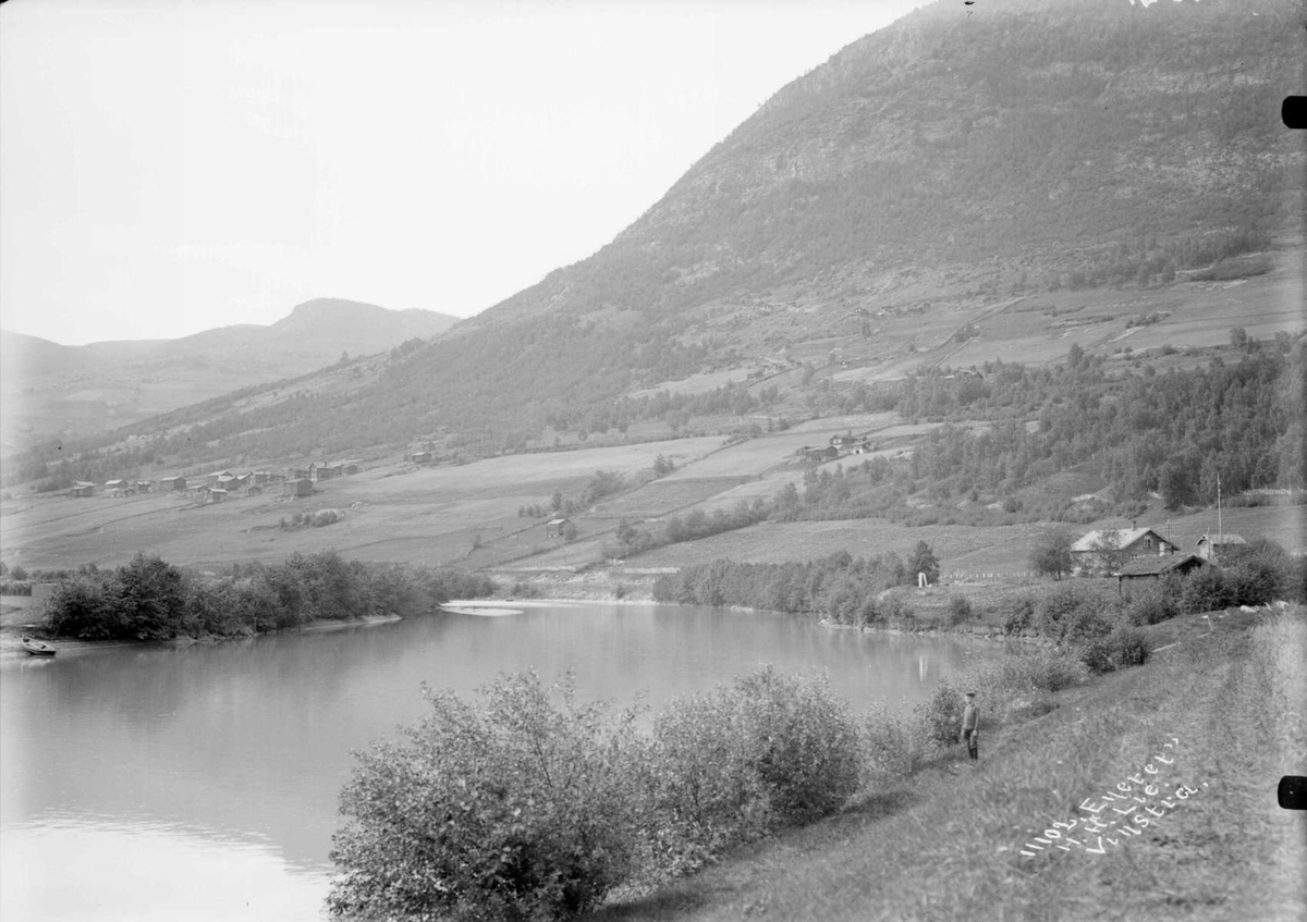 02.08.1908. Kvam. Parti med vik med Sinklarstøtten (Sinclair). Bebyggelse, elvevik, skogkledd åsside.