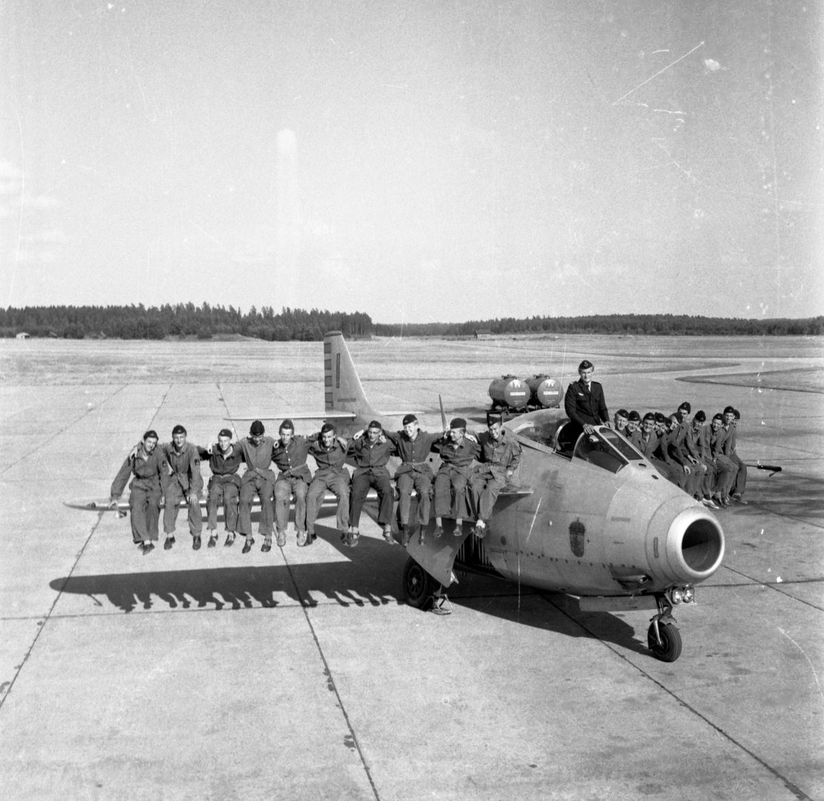 Gruppfoto på vingarna på J29 Tunnan med hjälp av personal vid Malmen. Flygplan. Flygvapenmuseum.