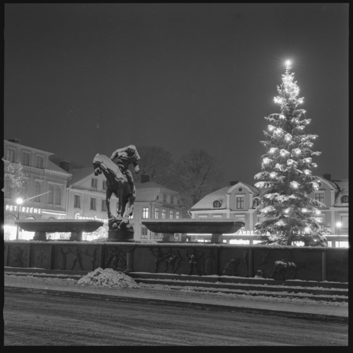 Folkungabrunnen med Folke Filbyter vid Juletid, krigsåren.
Folkungabrunnen med Folke Filbyter, skulpturen uppförd av Carl Milles, invigdes 1927. Inspirationskälla till detta verk var Verner von Heidenstams roman Folkungaträdet, där Folkungaättens undergång skildras. Folke Filbyter - ättens stamfader - avbildas, när han till häst letar efter sin bortrövade sonson. Det 16 meter långa brunnskaret i svart granit, fungerande som en barriär mellan torget och gatan, återger med sina reliefer episoder ur Folkungatidens historia.