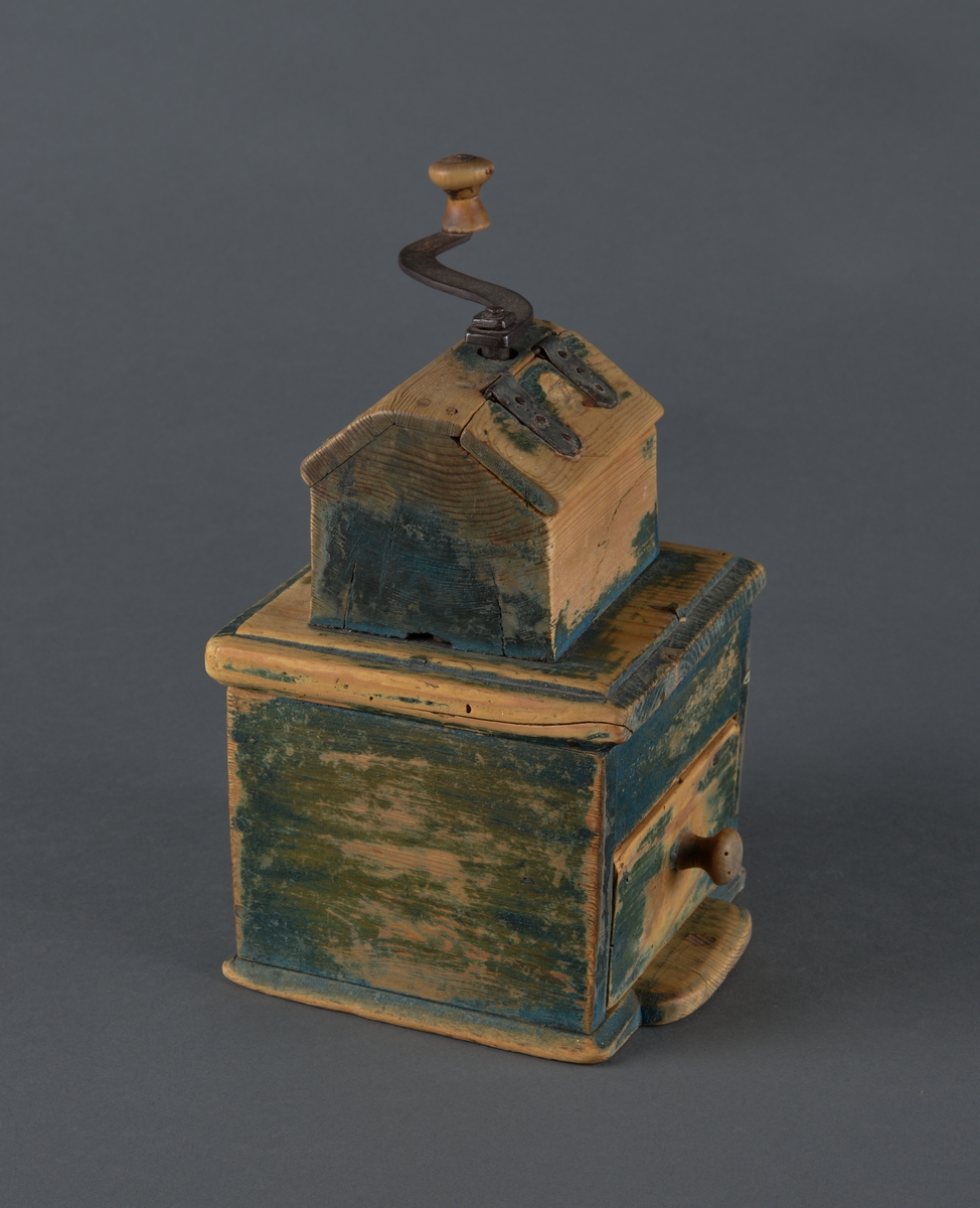 Kaffekvern i tre med kvadratisk bunn. Øverst et kaffehus med luke og innvendig kvern som dreies med en utvendig sveiv. Kvern og sveiv er i jern med en trekule til håndtak. Luka er hengslet til huset med streng. Nederst en utrekkbar skuff med trehåndtak. Kverna ser ut til å ha vært grønnmalt, men malinga er svært avslitt.