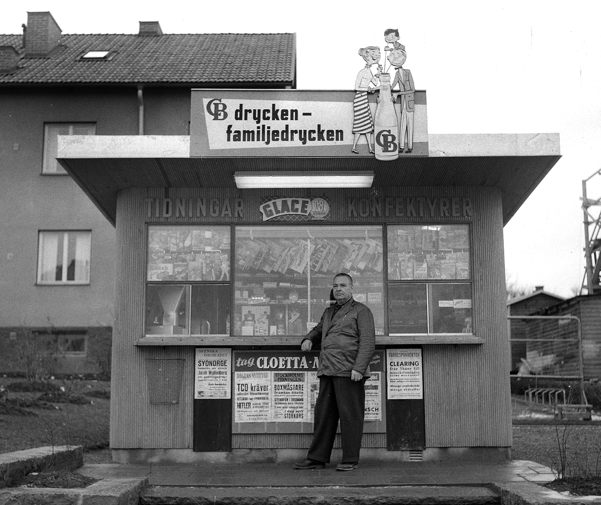 Martin Andersson vid sin kiosk utmed Grenadjärgatan i Linköping. Foto 1955.