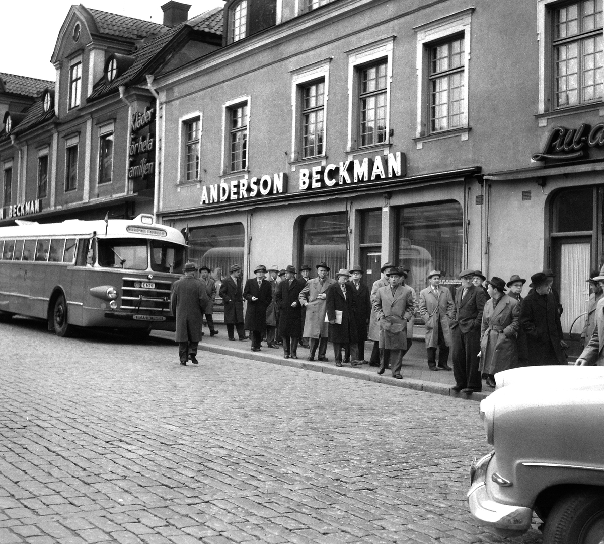 Serie bilder där fotografen följer en grupp herrar mot Stora hotellet i Linköping. Om vi tolkar fotoliggarens korta skrivelse rörde det sig om cykelhandlare som sammanförts av cykellyktstillverkaren Auto-Marin. 1957.
