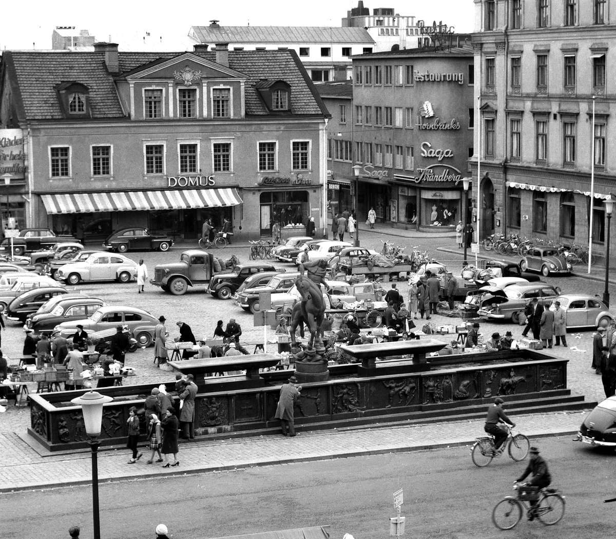 Stora torget i Linköping 1960. Ännu en tid skulle torghandlarna se sin handelsyta inskränkt av bilar. I övrigt känns miljön igen för dagens Linköpingsbor.