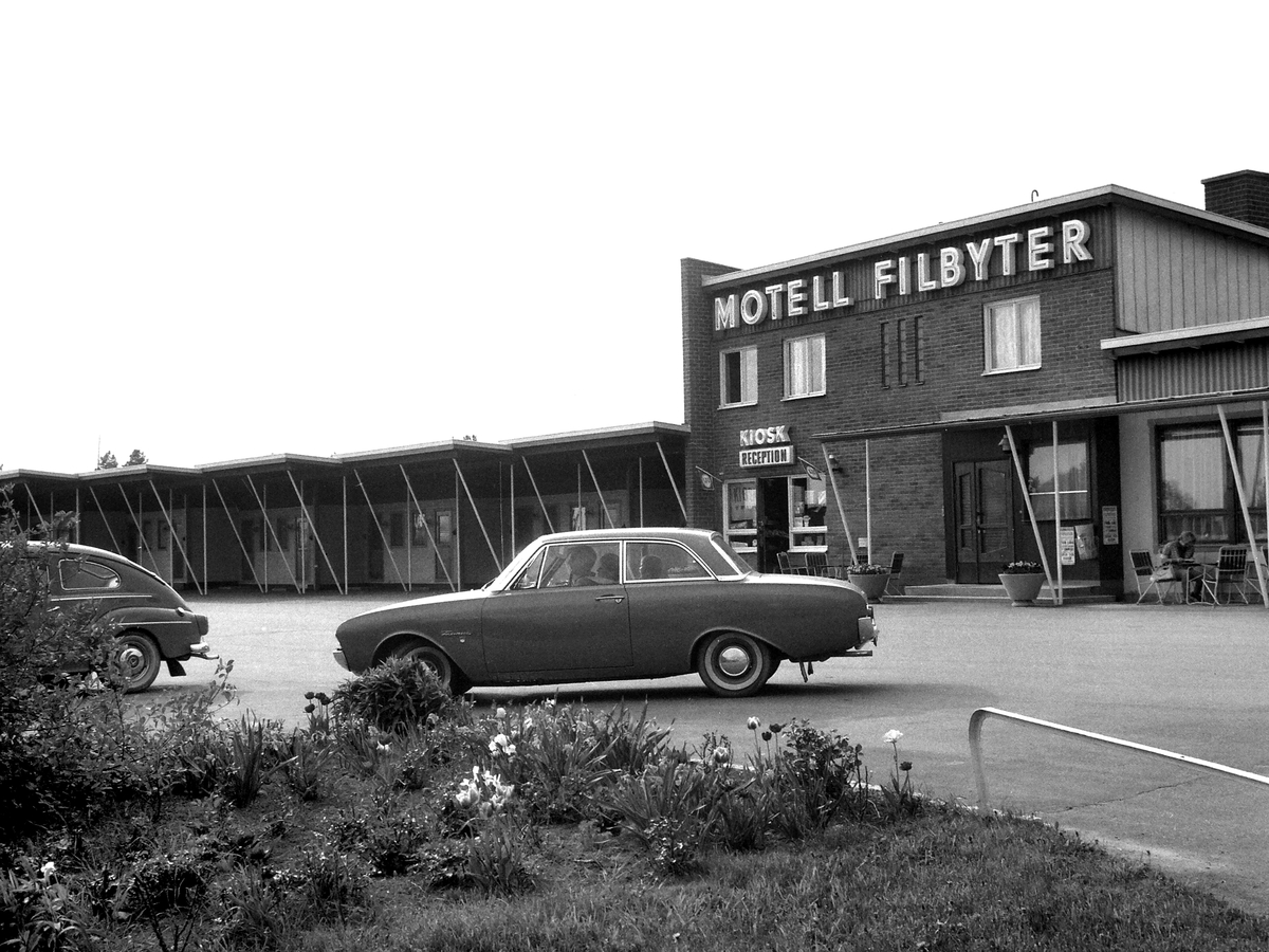 Motell Filbyter i Tallboda strax öster om centrala Linköping. Under 1950- och 1960-talen uppstod dessa bilismens miljöer utmed landets större vägstråk. Inspirationen kom från USA och hade där som här sin grund i beslut att sträva mot ett rikstäckande motorvägssystem. Anläggningen i Tallboda utmed Riksettan invigdes 1959 . Vid bildseriens tillkomst 1964 hade riksvägen i linje med ovan fått sitt nya vägnummer E4.
