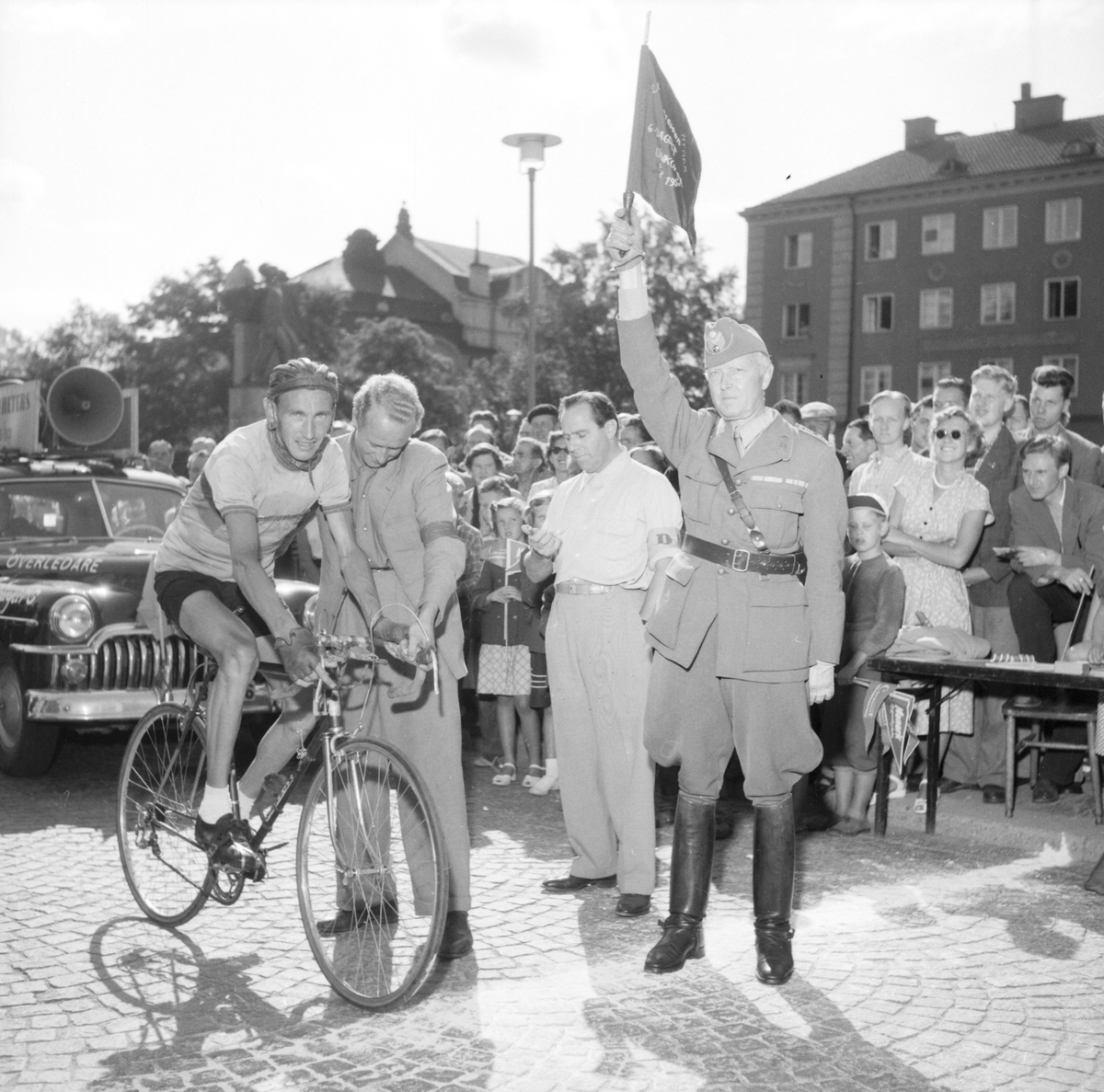 1953 års upplaga av cykeltävlingen 6-dagars hade Linköping som start- och målpunkt. Här en bild från startfållan på Vasavägen i höjd med Vasatorget. Bland personerna har Olof "Mantorparn" Johansson identifierats, mannen som hjälper den startande cyklisten att hålla balansen före start.