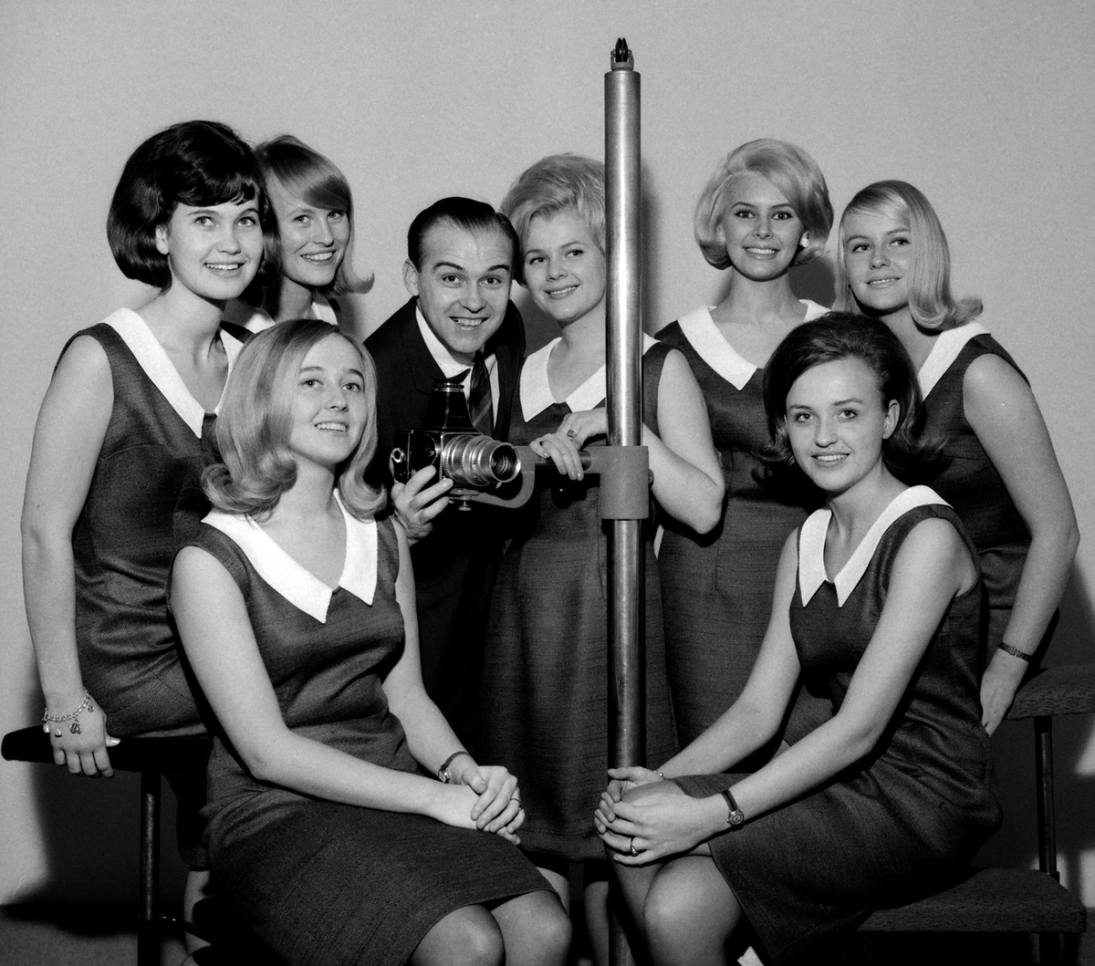 Linköpingsfotografen Arne Gustafsson omgiven av stadens luciakandidater 1964.