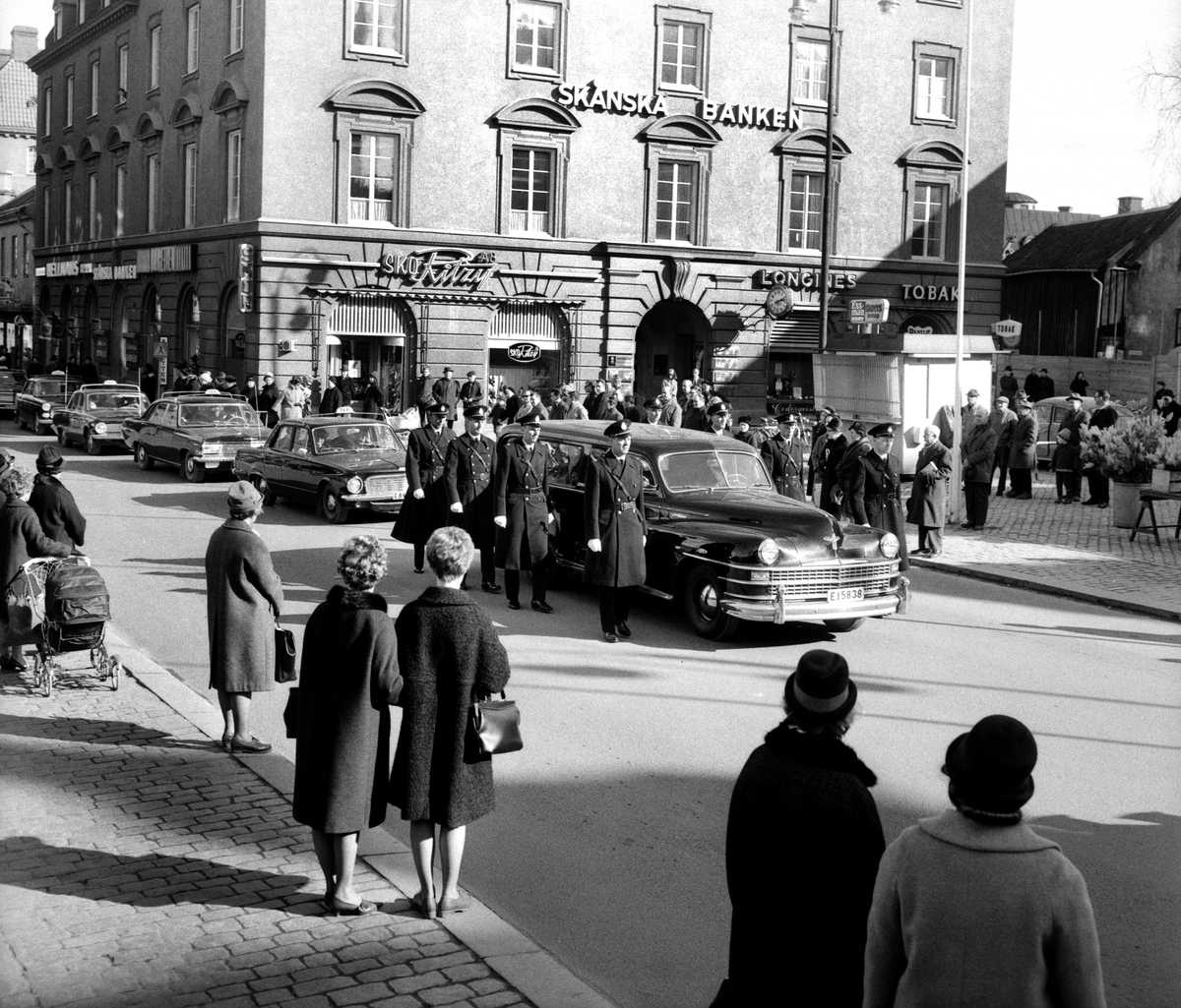 Serie bilder från efterspelet av den dramatiska händelse med tragiskt utgång som ägde rum strax öster om Sjögestad i mars 1965. Vid ett ingripande på platsen hade förste poliskonstapel Ragnar Nilsson blivit påskjuten och senare avlidit av skadorna. Begravningen i Sankt Larskyrkan i Linköping följdes av en begravningskortege genom staden till griftegården vid Malmslättsvägen. I serien förekommer även den 17-årige gärningsmannen på bild när han leds ut från Linköpings domsagas lokaler vid Barnhemsgatan.