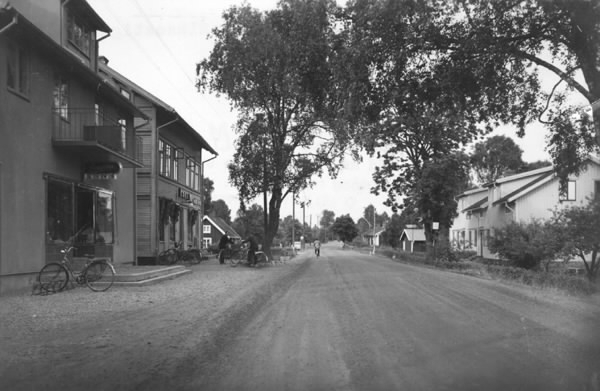 Nissastigen genom Rydöbruk med bostadshus och affärer, bland annat Bengtssons livs till vänster med parkerade cyklar utanför.