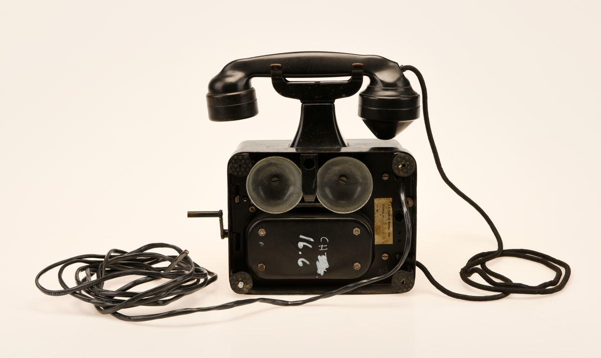 Sort bord/veggtelefon i Jernblikk og Bakelitt med sveivehåndtak. Telegrafverkets logo pryder fremsiden av aparatkassen. Ledningen som går fra aparatkassen til telefonrøret er av sort spiralisert tekstil. Telefonen har forøvrig en y-gaffel. Enden av ledningen som går til støpselet er kuttet av.