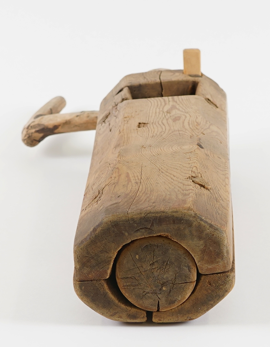 Potetkvern i tre. Består av ein sylinder med ei skrue inni, og ei sveiv. Ny låsepinne.