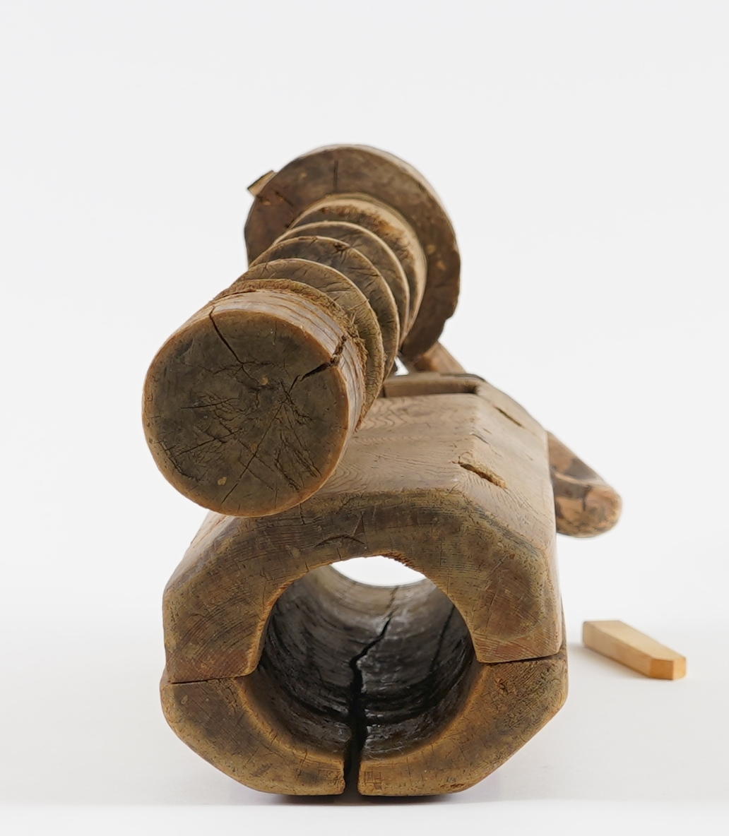 Potetkvern i tre. Består av ein sylinder med ei skrue inni, og ei sveiv. Ny låsepinne.