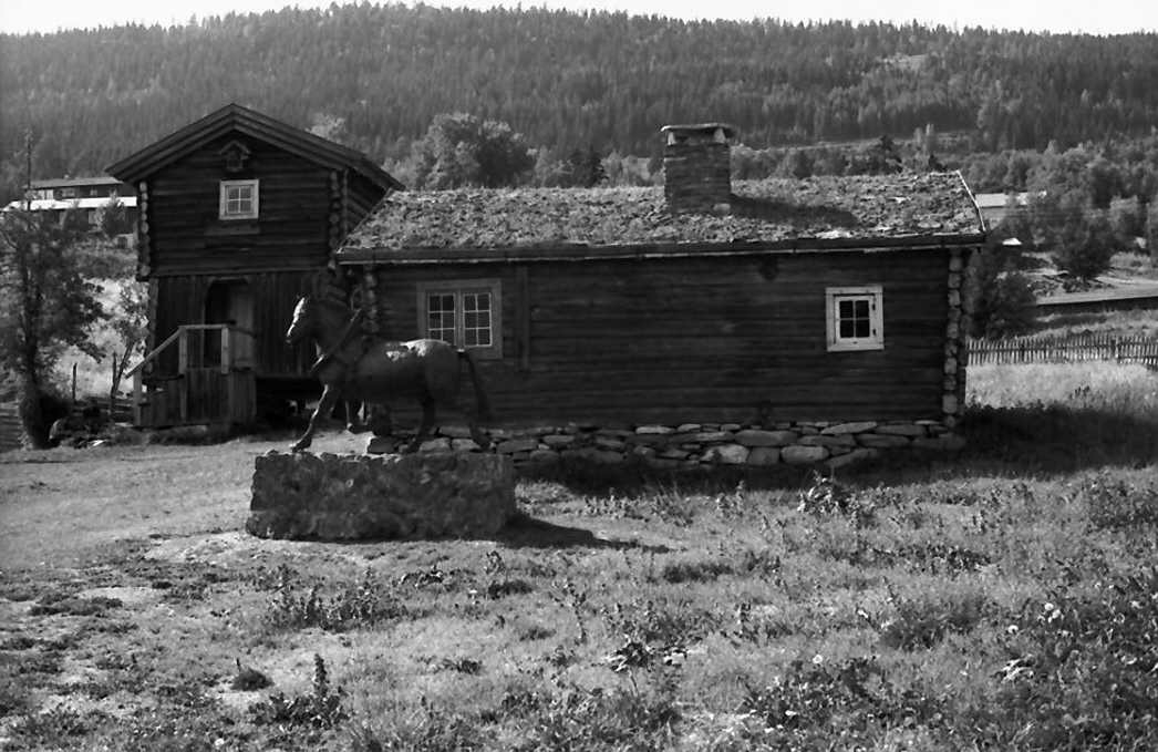 Drengstue, stabbur. Vesleblakkenstatue foran. 