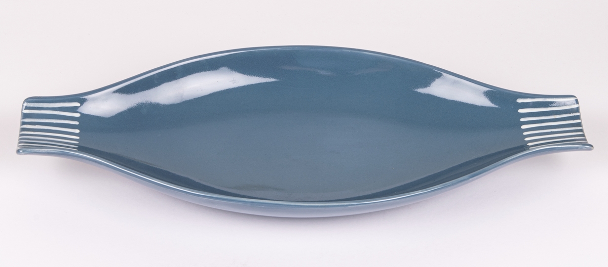 Skål i flintgods, modell M20 av Lillemor Mannerheim, formgiven 1957. Grå glasyr med vita ränder vid kortsidorna.