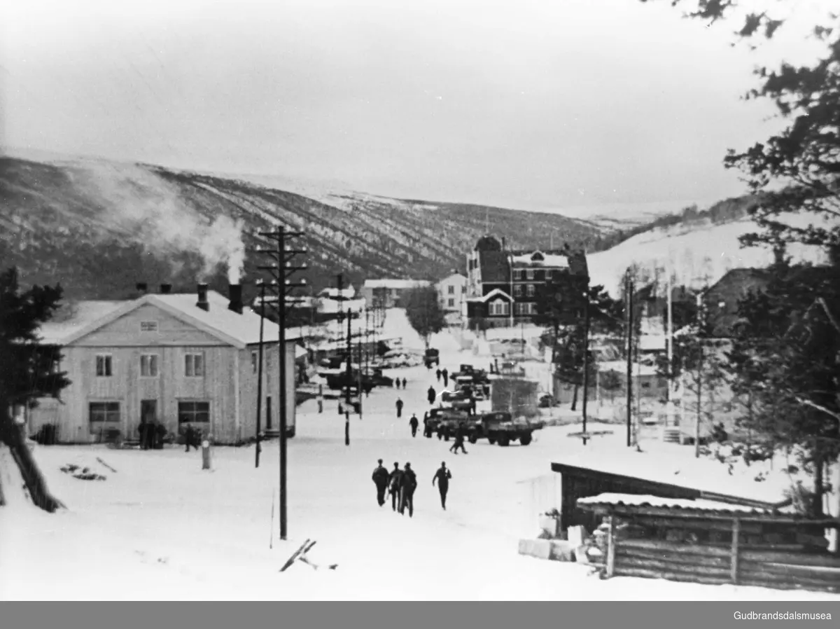 Dombås sentrum under krigen. Bildet er teke frå oppkøyringa mot Dovrefjell med Dombås samvirkelag (til v.) og Dombåsgarden og Dombås hotell i bakgrunnen.