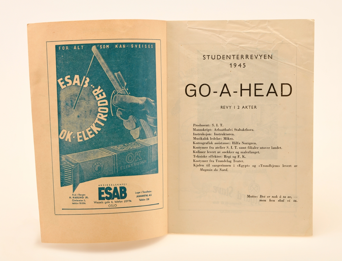 Programhefte for Go-a-head, UKA fra 1945. Dette heftet er identisk med standar heftet som ble utgitt, med unntak av skriften i sort øverst på forsiden: "15de UR-PREMIERE". Heftet inneholder selve programmet for UKA, en rekke sangtekster og reklamer fra diverse sponsorer. På forsiden ser vi en mann kledd i dress som rir en penn som om den skulle være en missil. Mannen holder fast i pennen med høyrehånden og en studentlue i sin venstre hånd. Øverst til venstre ser vi en liten sky som omgir en liten tekst. Under mannen ser vi artilleri som skyter i retningen den tidligere nevnte mannen kommer i fra. Nederst på forsiden ser vi noe som tilsynelatende er løpene til batterier. På disse står tekst som reffererer til navn til de 3 foregående UKA arrangementene nemlig: Tempora fra 1939, Vær-i-tass fra 1937, og Dek-e-du fra 1935. Heftet er på totalt 80 sider.