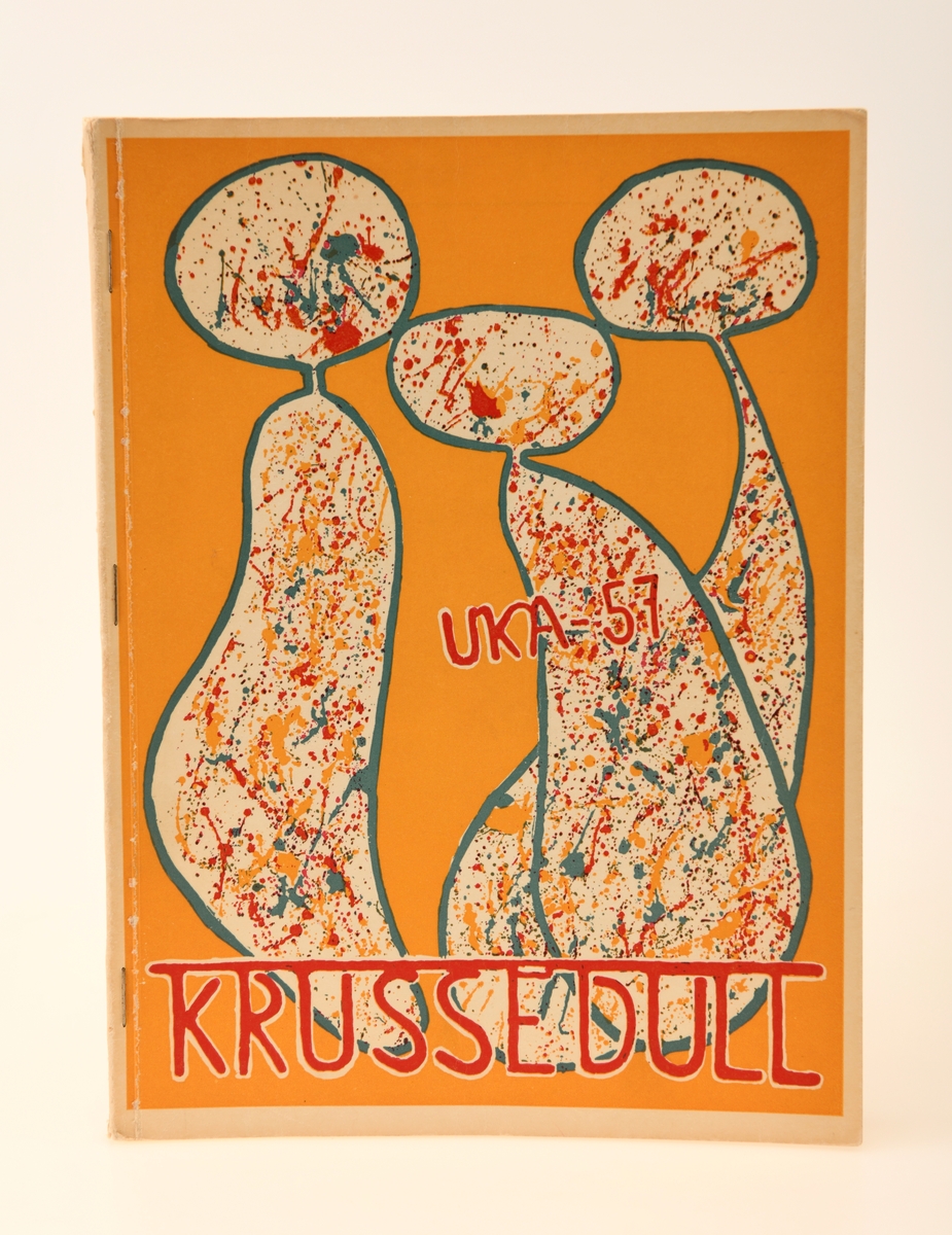 Programhefte for Krussedull, UKA fra 1957. Heftet inneholder selve programmet for UKA, en rekke sangtekster, et tilbakeblikk på "myndighetsdagen" i anledning at dette var den 21. UKA, og reklamer fra diverse sponsorer. På forsiden ser man tre hvite menneskelignende skikkelser. Skikkelsene er sprutet ned av fargene rødt, blått og gult. Heftet er på totalt 128 sider.