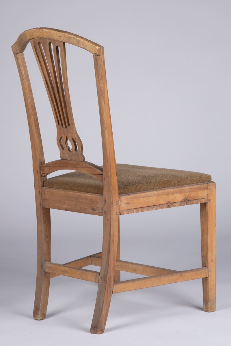 Rette, firkantete forben med enkel strek som dekor på hjørnene foran. Rettlinjet sarg, noe svsmalnende bakover og med enkel hulkilsbord langs underkanten av for- og sidesarger. H-kryss med rette sprosser, og en bindingsspross mellom bekbenene. Disse er firkantete med svak buing innover og bakover, og fortsetter opp i de avsmalnende, bakut og utadsvugne akterstavene. Buet toppstykke med enkel, skåret bladbord på overkanten. Gjennombrutt, vifteformet ryggbrett, oppdelt i fem spiler og gjennombrutt mønster nederst over festet i den buete tverrsprossen. Hele ryggrammen på fremsiden dekorert med to parraleltgående skråne striper. Fikk nytt beige velourtrekk fra Sellgrens veveri i 1939.