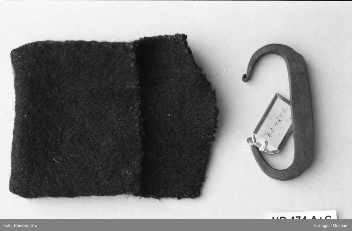 a) Ildstål, firkantet, C-formet, endene sterkt avsmalnende. L: 8,2 cm, br: 3,9 cm 
b) Flint-trekantet flintstykke
c) pung, ull, sort, konvoluttfasong. L: 9,2 cm, Br: 2,2 cm.