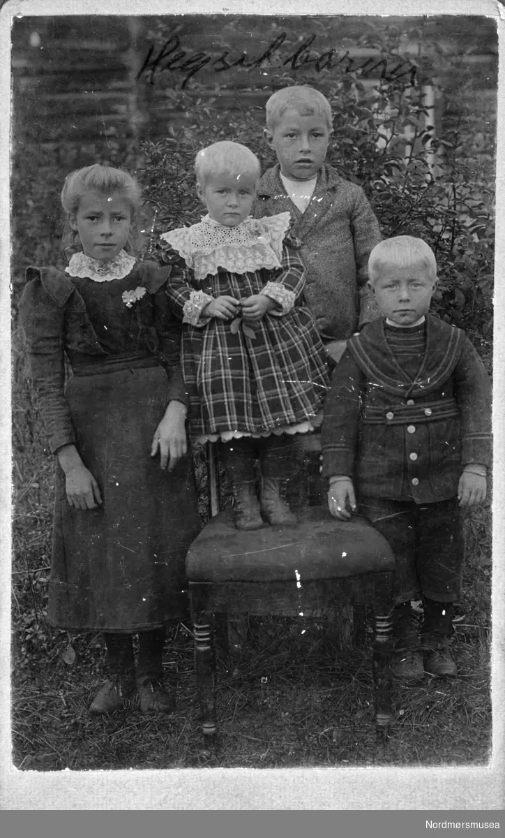 Fra venstre: Mali Heggset (f. 1891), Ingeborg Heggset (f. 1897), Rasmus Heggset (f. 1893) og Kristoffer Heggset (f. 1895). Fotograf er trolig F. O. Knudsen. 1899. Fotografiet er fra en fotosamling bestående av fire album gitt (digitalt) i gave til Nordmøre museum av Astrid Kvendbø. Originalmaterialet er returnert eier. Fra Nordmøre museums fotosamlinger.