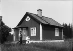 Familj utanför bostadshus, Duderö, Börstils socken, Uppland