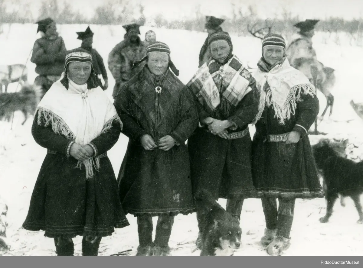 Nissonolbmot ja dievdoolbmot olgun.
Kvinner og menn ute.

Per Josefsen Buljo, Johan Anti (Márgge-Joavnna), Josef Buljo, Alf Wiig, Per Boine, Inga Josefsdtr. Buljo, Karen Marie Johansdtr. Nango, Marit J. Buljo