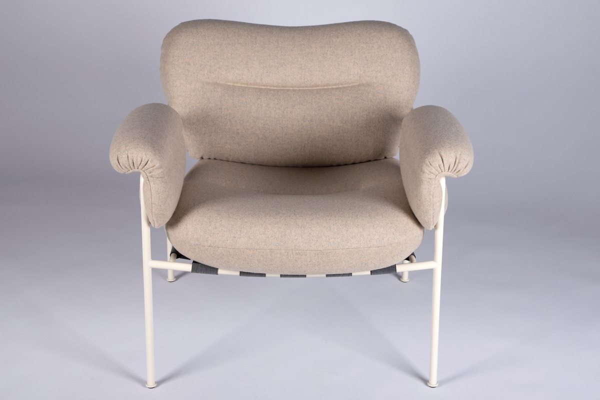 Hvitlakkert stålramme av runde, slanke rør. Runde luftige putter med hvitt ullstoff. Sete ligger i et tøynett som er festet i rammen.