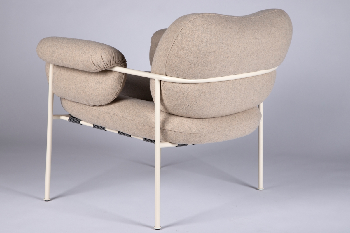 Hvitlakkert stålramme av runde, slanke rør. Runde luftige putter med hvitt ullstoff. Sete ligger i et tøynett som er festet i rammen.