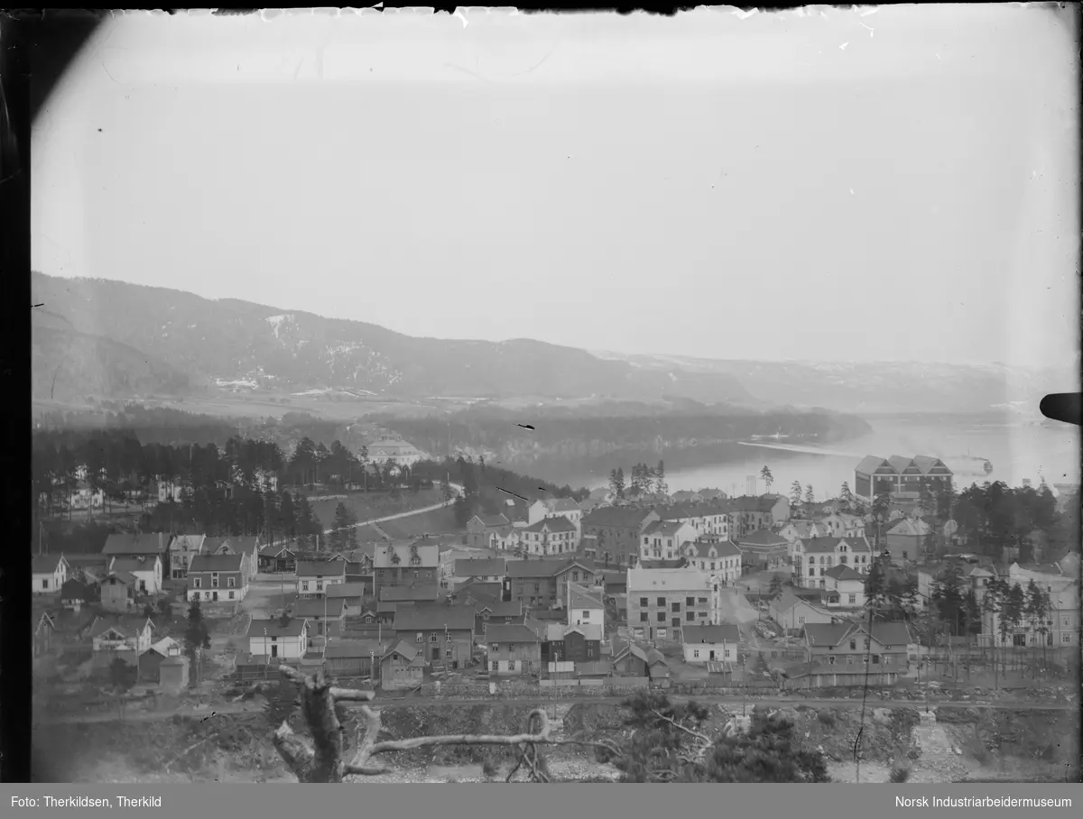 Oversiktsbilde over Notodden sentrum fra Nordre Tinnes. Boliger og næringsbygg i sentrum, boliger i Villamoen og Norsk Hydros administrasjonsbolig.