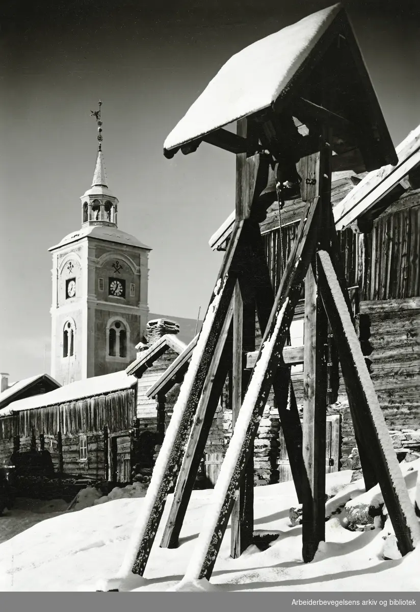 Røros kirke med Hyttklokka i forgrunnen. Hyttklokka ble brukt til å varsle arbeiderne på smelthytta om når arbeidet begynte og sluttet. Udatert