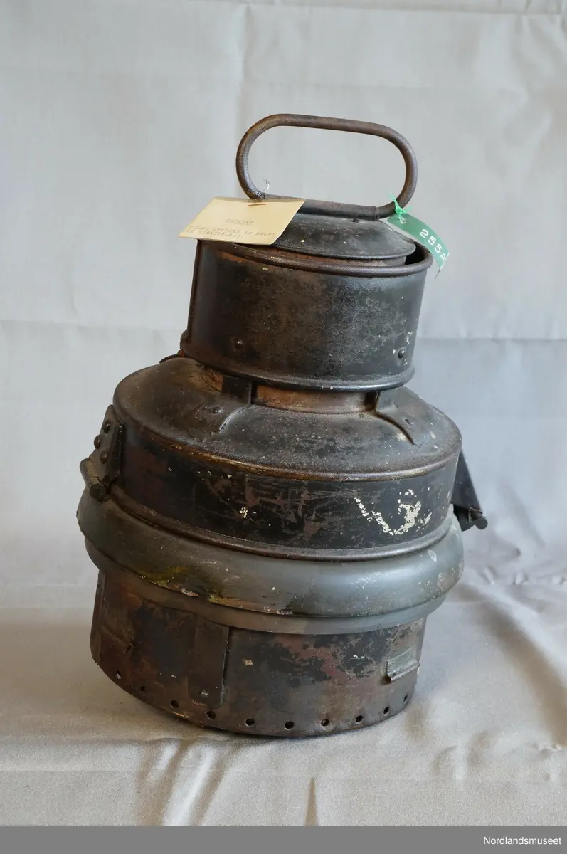 Formet som en boks med flere ulike nivå i omkrets. Øverst er det et håndtak. Under lampen er det festet en L-formet lighterfunksjon, hvor det tennes en ild som igjen gir lys.