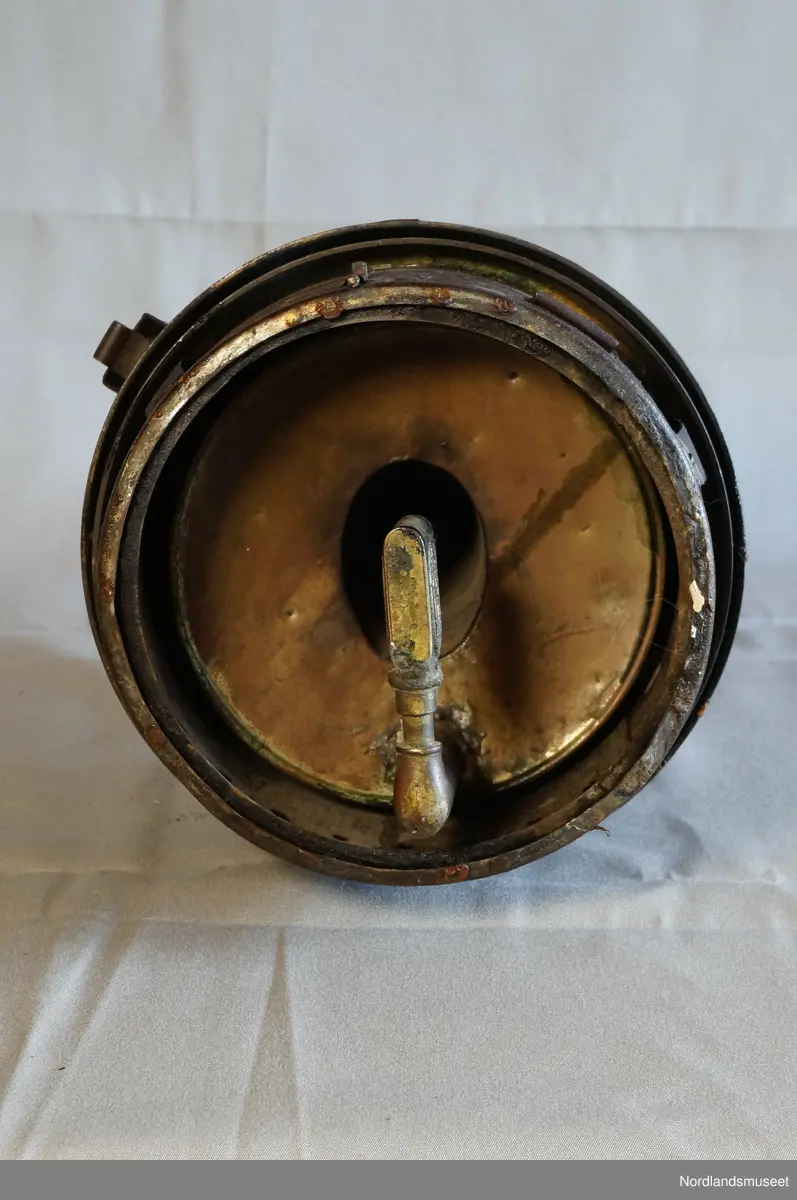 Formet som en boks med flere ulike nivå i omkrets. Øverst er det et håndtak. Under lampen er det festet en L-formet lighterfunksjon, hvor det tennes en ild som igjen gir lys.