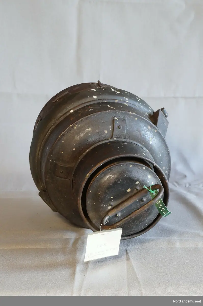 Formet som en boks med flere ulike nivå i omkrets. Øverst er det et håndtak. Under lampen er det festet en L-formet lighterfunksjon, hvor det tennes en ild som igjen gir lys.