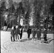 Realskolan vinterlov januari 1961. Några unga männsikor står uppställda framför kameran för fotografering. De har skridskor på fötterna och de står på en snöklädd isbana. Alla bär pälsmössa eller sjalett på huvudet.