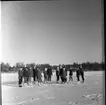 Realskolan vinterlov januari 1961. Några unga männsikor står uppställda framför kameran för fotografering. De har skridskor på fötterna och de står på en istäckt sjö. Alla bär pälsmössa eller sjalett på huvudet.