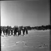 Realskolan vinterlov januari 1961. Några unga männsikor står uppställda framför kameran för fotografering. De har skridskor på fötterna och de står på en istäckt sjö. Alla bär pälsmössa eller sjalett på huvudet.