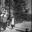 Realskolans vinterlov januari 1961. En klunga unga personer fikar vid en strandkant. Det är vinter och stranden är istäckt. På isen står en spark. 

Negativet är skadat och svarta fläckar syns i bilden.