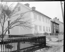 Ett putsat tvåvåningshus fotograferat från gatan utanför. Det ligger snö på marken