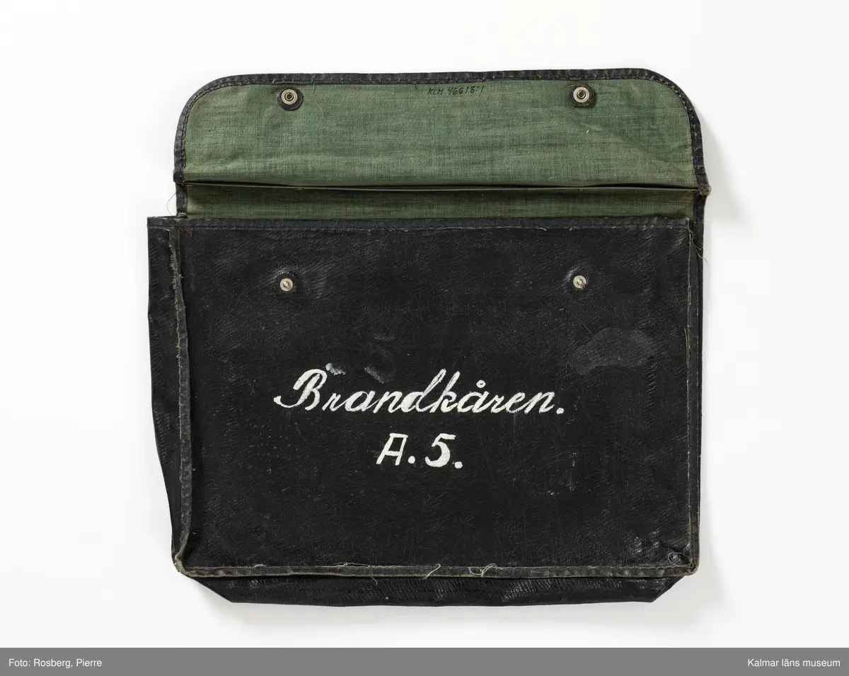 KLM 46618:1:1-16. Väska. :1: Svart väska av plastmaterial, på utsidan svart och insidan grön. Lock som stängs med tryckknappar. Handtag. Påmålad text i vitt framsida: Brandkåren A.5. Väskan innehåller pappersdokument :1:1-16.

:1:1. Allmän kungörelse. Nr 69. Luftskyddsövningar i luftskyddsorterna Kalmar, Nybro och Västervik. Länsstyrelsen Kalmar 1944. Kalmar Tryckeri Aktiebolag. 
:1:2. Övningstekniska anvisningar för luftskyddsövningar, Länsstyrelsen.
:1:3. Rapportblock. Sven Lindegrens tryckeri, Kalmar.
:1:4. Rapportblock. Sven Lindegrens tryckeri, Kalmar.
:1:5. Rapportblad, häftat på masonitskiva.
:1:6. Meddelandeblock. Sven Lindegrens tryckeri, Kalmar.
:1:7. Meddelandeblock. Sven Lindegrens tryckeri, Kalmar.
:1:8. Telefonförteckning för luftskyddet i Kalmar 1 sko. Sju sidor, häftad. Upprättad den 27/1 1944.
:1:9. Utrustningslista. Brandkårsavdelning A5.
:1:10. P.M. Till tjänstecheferna.
:1:11. Föreskrifter vid ockupation och vid hot om ockupation, två sidor. Upprättat för Luftskyddsinspektionen och inkom den 10/9 1943. Sida två upprättat den 7/10 1943.
:1:12. Dokument rörande uppställningsplatsen och förläggningsstället Funkaboskolan för Brandkårsavdelning A.5.
:1:13. Förutsättning och program för luftskyddsövning i Kalmar den 20-21 mars 1944.
:1:14. P.M. för tjänstegrenschefer och avdelningschefer m.fl. vid brandtjänsten, fram och baksida.
:1:15. Förteckning över rapportställe, förteckning över brandtjänsten.
:1:16. Exempel på förfarande vid skadeplats.