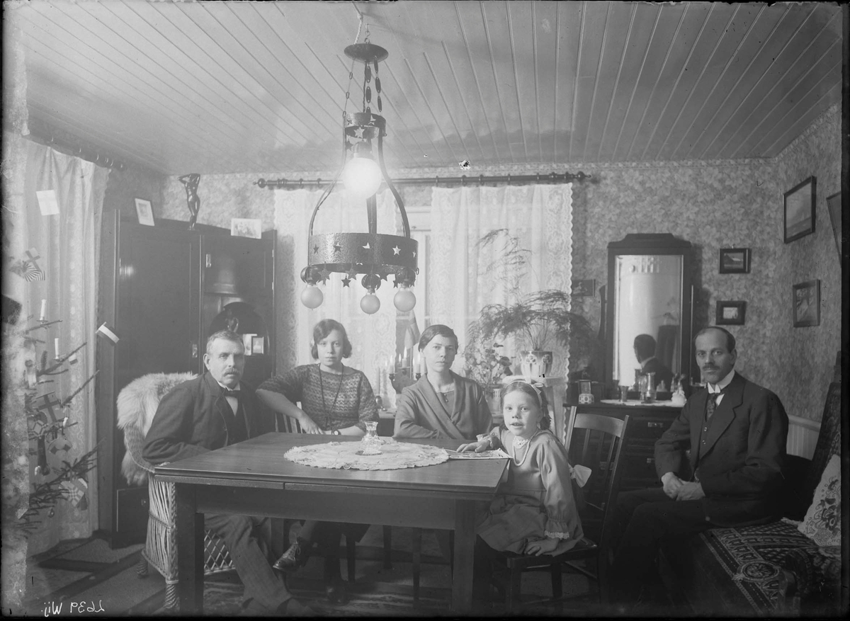 Fotografering beställd av Persson. Föreställer sannolikt filaren Johan Herman Persson (1888-1963) med hans hustru Edit Charlotta Pettersson (1893-1977) och deras dotter Irene Charlotta (1918-2011). De andra är ej identifierade.