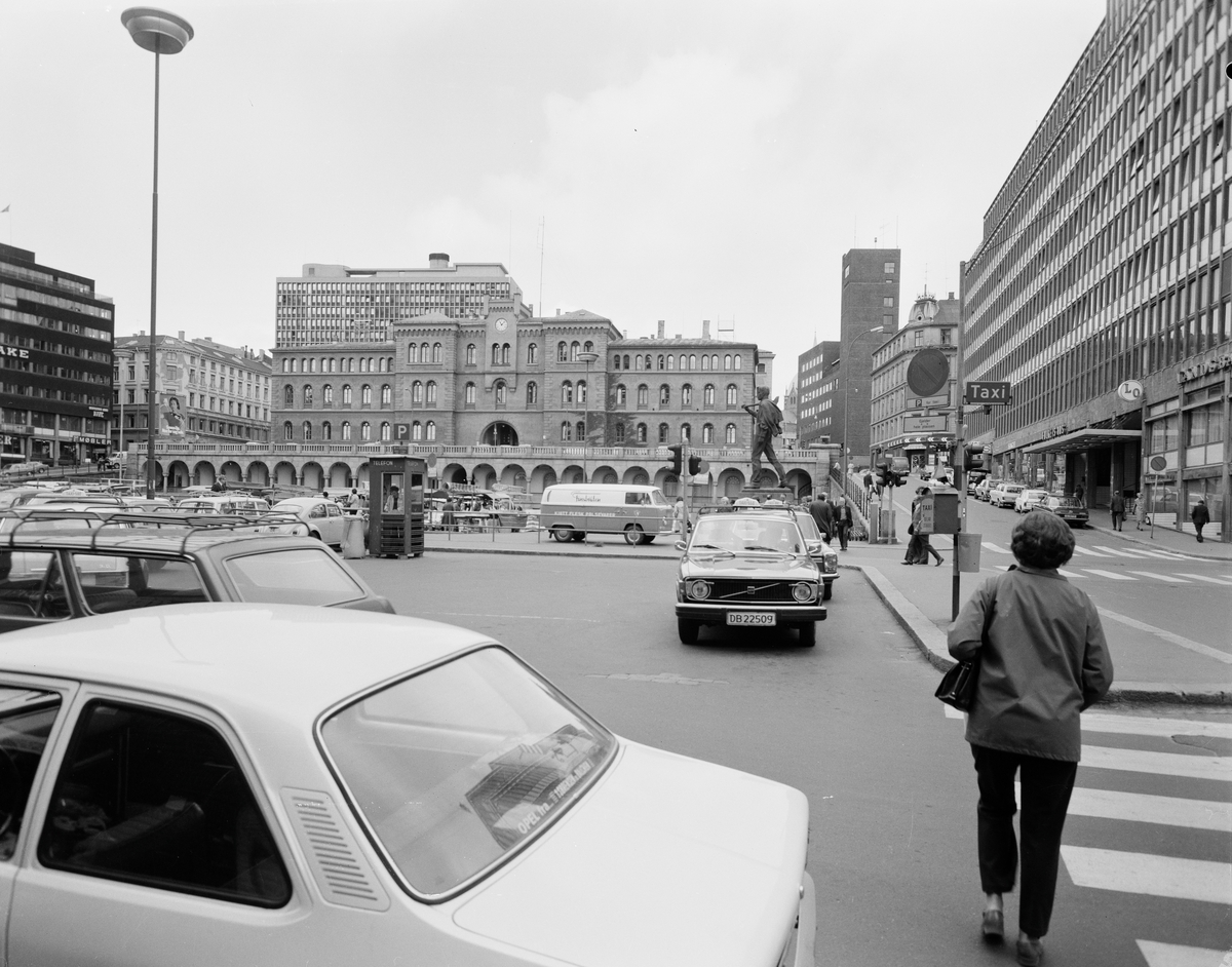 Utsikt til Møllergata 19 fra Youngstorget. Biler står parkert på torget.