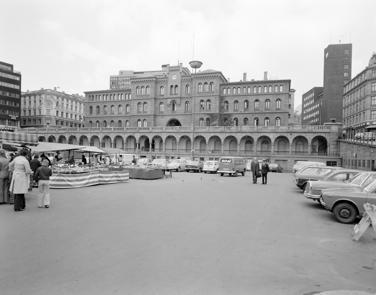 Utsikt til Møllergata 19 fra Youngstorget. Biler står parkert på torget.